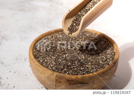 Chia seeds fall in wooden bowl. Healthy superfood rich in Omega 3 fatty acids. Dry healthy natural ingredient. Chia grains are falling 119819167