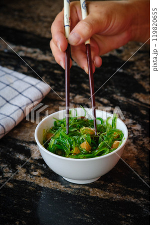 Wakame salad in a bowl and bamboo sticks 119820655
