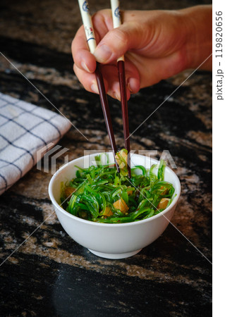 Wakame salad in a bowl and bamboo sticks 119820656
