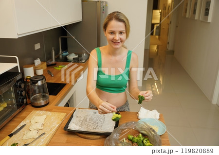 A young woman joyfully prepares a variety of healthy meals  119820889