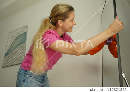 A woman is cleaning her living room at home A woman is cleaning her living room at home 119821225