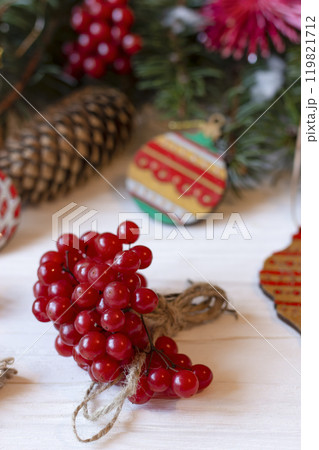 DIY decorations for Christmas. Rural style Christmas with eco-conscious details: snowball tree, cones and wooden handmade decorations for the Xmas tree on pine branches. New Year natural wooden toys. 119821712