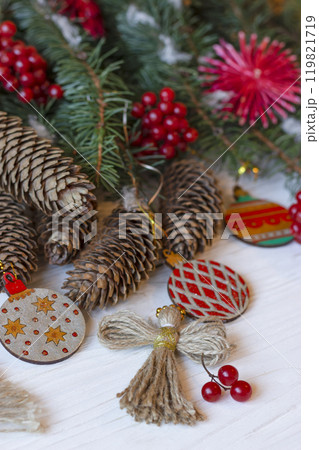 DIY decorations for Christmas. Xmas ornaments. Christmas composition with Ukrainian doll-motanka, wood balls, snowball tree, cones and fir branches. New Year eco-conscious handmade toys. Happy holiday DIY decorations for Christmas. Xmas ornaments. Christmas composition with Ukrainian doll-motanka, wood balls, snowball tree, cones and fir branches. New Year eco-conscious handmade toys. Happy holiday 119821719
