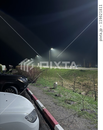 A mesmerizing nighttime scene unfolds with soft parking lights illuminating the fog 119821811