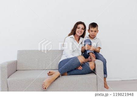 Mom and son sitting at home on the couch 119821948