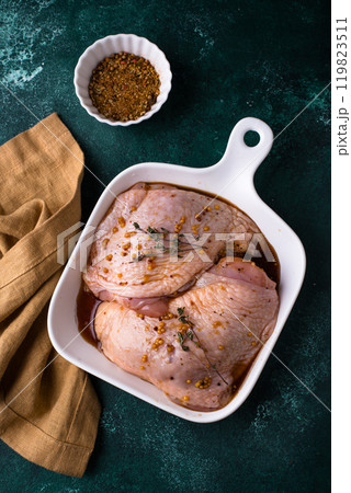 Raw chicken thighs on dark kitchen table 119823511