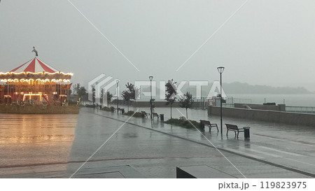 Lonely Deserted Carousel In The Rain With Bright Lights And A Glimmering Reflection On The Ground Lonely Deserted Carousel In The Rain With Bright Lights And A Glimmering Reflection On The Ground 119823975