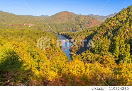 紅葉の萌える山々と只見川橋梁を渡る機関車 119824289