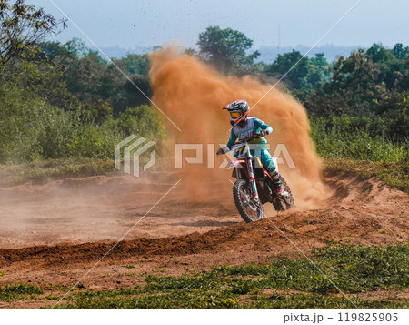 A biker creates a large cloud of dust and debris, Motocross concept 119825905