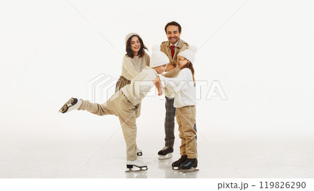 Happy winter weekends. Joyful smiling family, parents and tow kids enjoying lovely time on ice rink. Cozy warm outfits Happy winter weekends. Joyful smiling family, parents and tow kids enjoying lovely time on ice rink. Cozy warm outfits 119826290