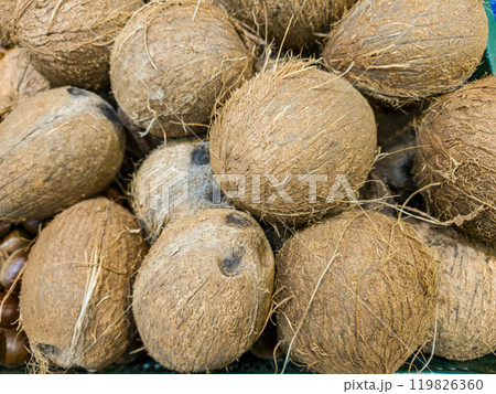 Coconuts on the counter in the store. Coconuts close-up background Coconuts on the counter in the store. Coconuts close-up background 119826360