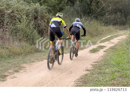 back two athletes riding mountain bike in cross country race 119826713