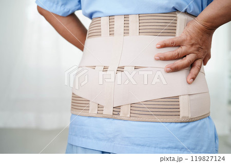 Asian senior wearing elastic support belt can help reduce back pain. Asian senior wearing elastic support belt can help reduce back pain. 119827124