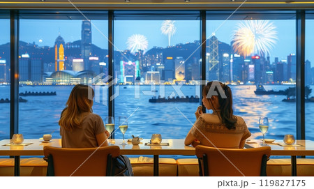 Two Friends Enjoying Fireworks Over Hong Kong's Skyline While Dining at a Waterfront Restaurant Two Friends Enjoying Fireworks Over Hong Kong's Skyline While Dining at a Waterfront Restaurant 119827175