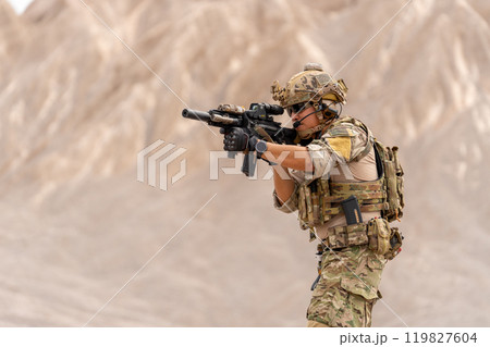 Military or soldier with point gun to left side and stay in battlefield near the mountain during outdoor practice. Military or soldier with point gun to left side and stay in battlefield near the mountain during outdoor practice. 119827604