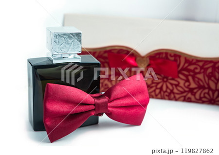 Elegant Black Perfume Bottle With Red Bow Tie and Decorative Box on White Background. 119827862