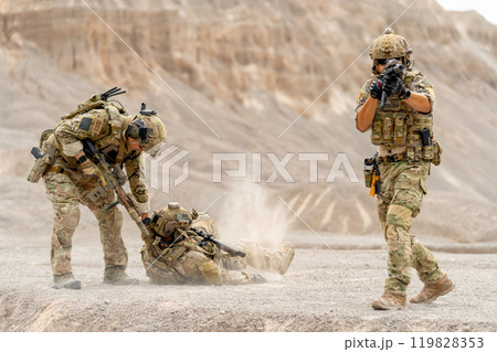 One of Military or soldier try to pull member of his team along the way to escape the danger and protect by the other one point gun to front upper to enemy. 119828353