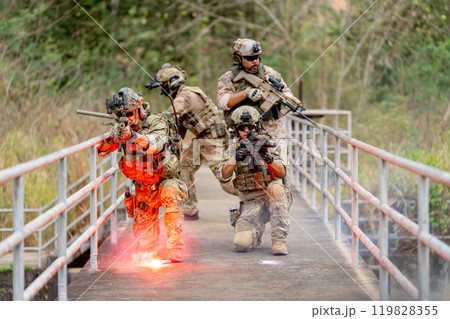 Group of military or soldier team with battle suit stay on the bridge near flare firework in position for battle and point gun different direction during outdoor practice. Group of military or soldier team with battle suit stay on the bridge near flare firework in position for battle and point gun different direction during outdoor practice. 119828355
