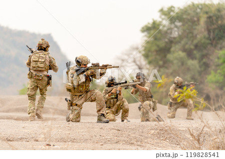Group of soldiers or military sit and hold gun point to the enemy to practice the formation for fighting in battlefield. 119828541