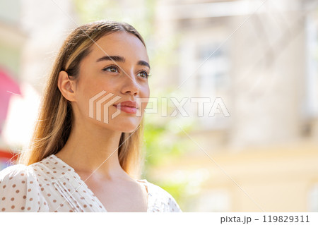 Close-up portrait of happy woman face smiling open eyes glad expression looking away dreaming 119829311