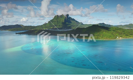 Breathtaking tropical island panorama with turquoise water lagoon bay, green rainforest, sailing boats, volcanic mountain peak in background. Bora Bora popular tourist destination exotic summer travel 119829342