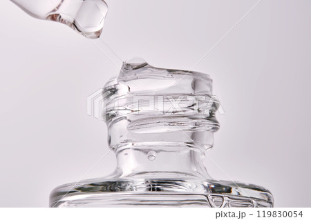 Close-up of a cosmetic bottle with a pipette showing the texture of the serum. 119830054