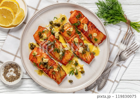 salmon piccata with lemon caper sauce on plate 119830075