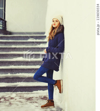 Fashion pretty cool girl wearing jacket and hat in winter city 119830334
