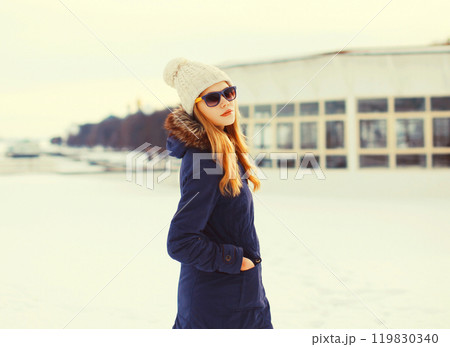 Fashion winter pretty blonde woman wearing a jacket hat and sunglasses 119830340