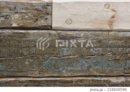 a close-up view of aged and weathered wooden planks stacked together 119830590