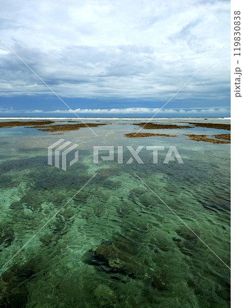 Panoramic views of the incredibly beautiful ocean. Clear turquoise water behind a reef on a deserted beach on the tropical island of Bali. Panoramic views of the incredibly beautiful ocean. Clear turquoise water behind a reef on a deserted beach on the tropical island of Bali. 119830838