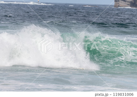 Wave of the green and blue Atlantic Ocean at the edge of a beach in the Iroise Sea. 119831006