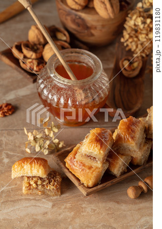 Baklava with walnuts and honey on a beige background. 119831180