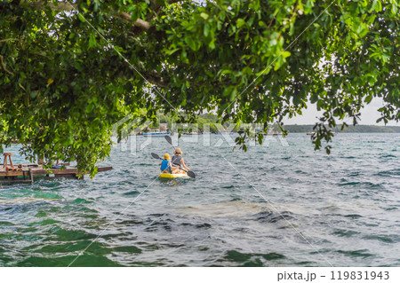 Mother and son tourists kayaking on Bacalar Lake in Mexico. Adventure tourism in Quintana Roo, outdoor exploration, and water activities concept 119831943