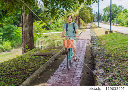 Man tourist cycling through the charming village of Bacalar, Mexico. Quintana Roo travel, scenic bike paths, and eco-friendly exploration concept 119832405