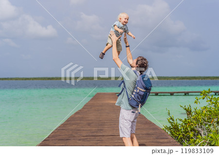 Father with his toddler son exploring wooden pier over the turquoise waters of Bacalar Lake, Mexico. Peaceful tropical travel destination concept Father with his toddler son exploring wooden pier over the turquoise waters of Bacalar Lake, Mexico. Peaceful tropical travel destination concept 119833109