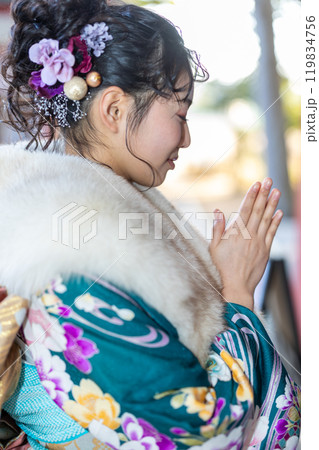 神社でお参りする晴れ着の若い女性 119834756