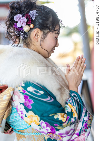 神社でお参りする晴れ着の若い女性 119834757