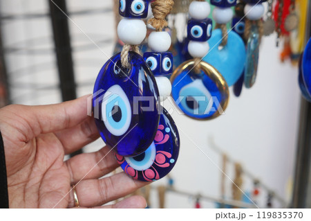 a bunch of blue evil eye keychains hanging on a shelf 119835370