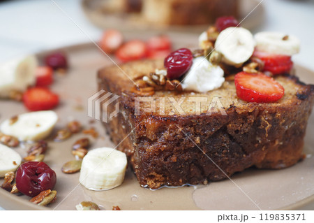 Enjoy this exquisitely Deliciously Topped Banana Bread, adorned with Fresh Fruits and Nuts 119835371