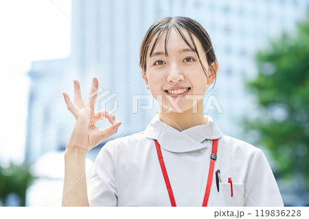 応援のポーズをする若い看護師 応援のポーズをする若い看護師 119836228