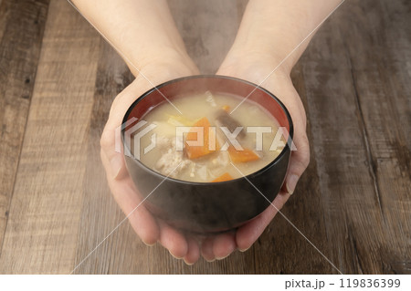 湯気の立つ味噌汁を手で持つ　配膳する 119836399