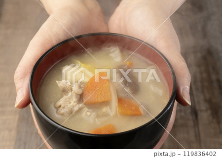 湯気の立つ味噌汁を手で持つ　配膳する 119836402