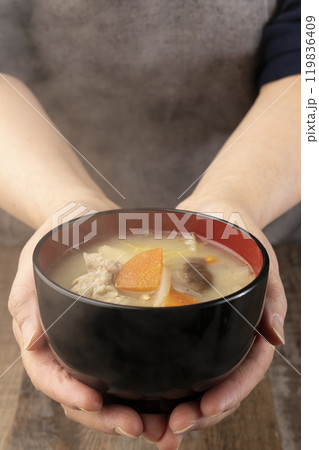 湯気の立つ味噌汁を手で持つ　配膳する 119836409