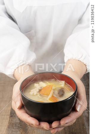 湯気の立つ味噌汁を手で持つ　配膳する 119836412