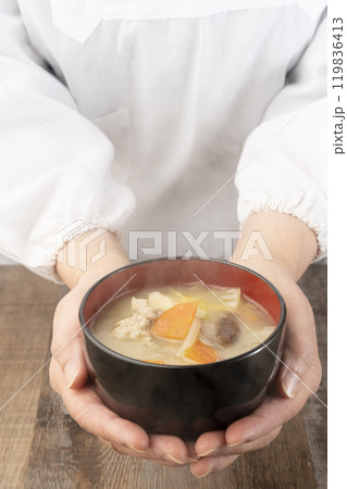 湯気の立つ味噌汁を手で持つ　配膳する 119836413
