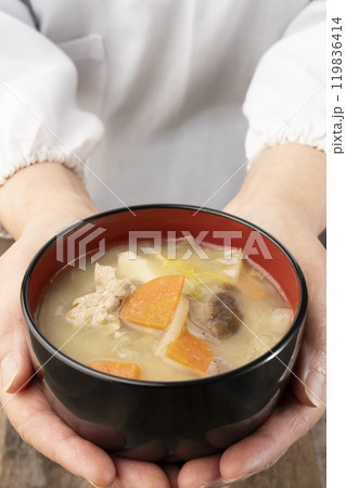 湯気の立つ味噌汁を手で持つ　配膳する 119836414
