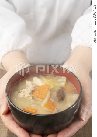 湯気の立つ味噌汁を手で持つ　配膳する 119836415