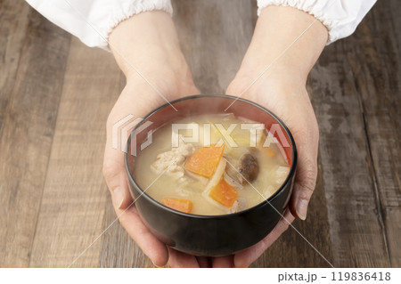 湯気の立つ味噌汁を手で持つ　配膳する 119836418