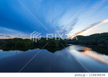 中秋の奈良市東部大和高原にある布目ダムの夕景 山際から伸びる一筋の黄金雲と放射状に伸びる暗雲 中秋の奈良市東部大和高原にある布目ダムの夕景 山際から伸びる一筋の黄金雲と放射状に伸びる暗雲 119836636